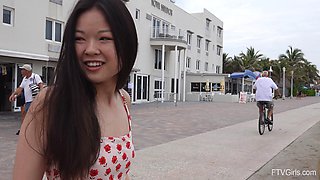 Asian amateur Lulu lifts her miniskirt to flash her pussy in outdoors