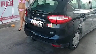 naked woman washes a car at a car wash